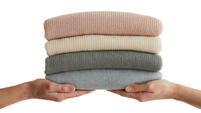 person hands holding a stack of folded clothes. Isolated on transparent background, png