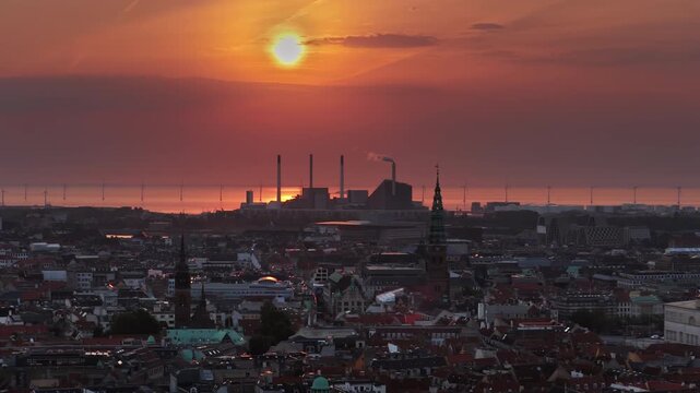 Aerial drone view of the skyline of Copenhagen, Denmark with Amager Bakke and offshore wind turbines at sunrise