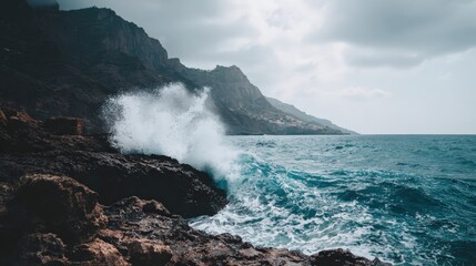 Coastal waves crashing against rocky shoreline under moody sky