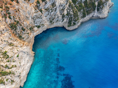 Aerial view of the rugged, light-colored cliffs meeting the turquoise waters of Porto Katsiki beach, Lefkada, Lefkada, Greece.