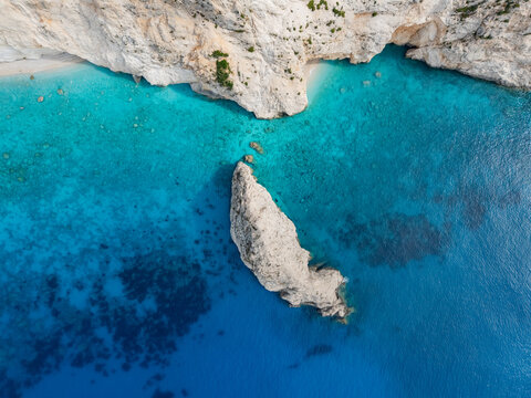 Aerial view of the turquoise waters contrasting with the towering white cliffs and a solitary rock formation at Porto Katsiki beach, Lefkada, Lefkada, Greece. - Powered by Adobe