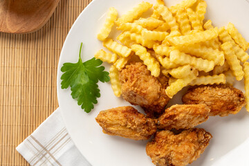 Fried chicken wings and crinkle cut fries on plate