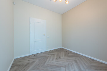 Empty Home Beige Room with White Door and Light Parquet Flooring