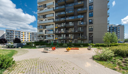 Modern Residential Home Buildings with Spacious Courtyards and Playgrounds on Sunny Day