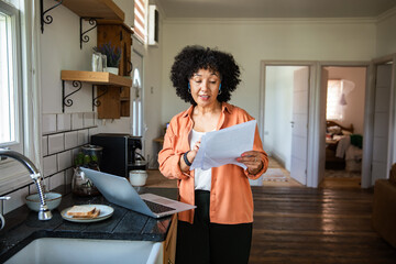 Mature woman reviewing documents at home