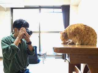 ペットのねこを撮影する男性