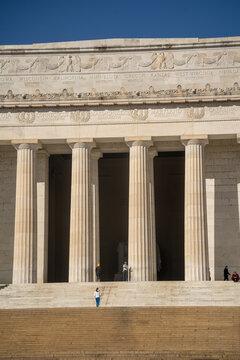 View of the Lincoln Memorial's grand facade with its Doric columns and intricate friezes under a crisp blue sky, Washington, D.C., United States.