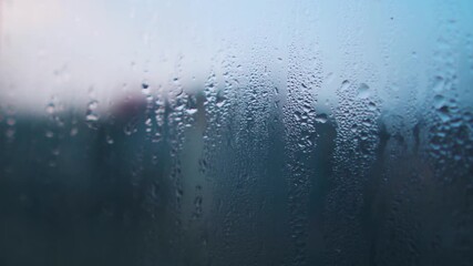 Closeup shot of water droplets on the window of a vehicle during the winter season due to the cold and fog at Delhi in India. Water droplets on the window of a car in early morning. Droplets on glass.