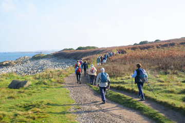 Obraz premium Groupe de randonneurs sur le GR34 de l'île Grande en Bretagne - France