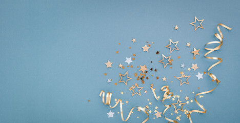 New Year, Christmas or birthday blue festive background top view. Celebration composition with golden confetti stars and serpentine party streamers.