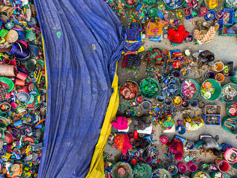 Joypurhat, Bangladesh - 25 September 2022: Aerial view of a vibrant tapestry of recycled plastic, with women sorting through piles of colorful materials, creating a mosaic of textures and hues.