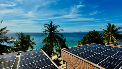 Solar panels on tropical resort rooftops overlook turquoise sea and palm trees. The image captures sustainable energy blending with paradise island scenery on a sunny day. © Houston