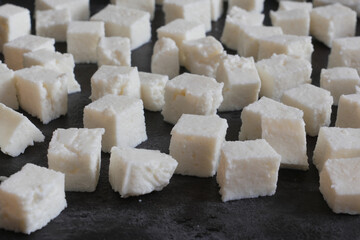 Indian cottage cheese, paneer, diced on metal tray for making matar paneer curry.