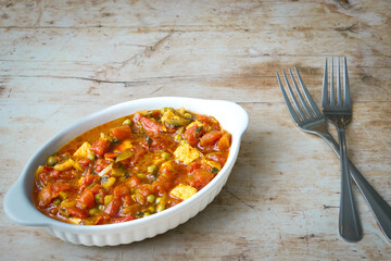 Homemade spicy matar paneer curry, Indian cottage cheese with tomatoes, garden peas in dish