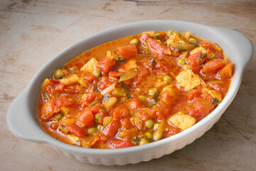 Spicy matar paneer curry featuring Indian cottage cheese, ripe tomatoes, and garden peas, served in dish