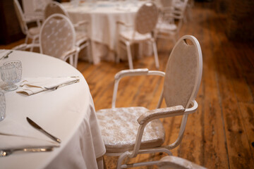 Elegant Event Seating Arrangement with White Tablecloths and Chairs Ready for Guests at an Indoor Gathering or Celebration