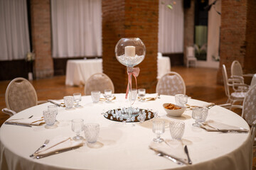 Elegant Wedding Reception Table Setting with Candle Centerpiece Glasses and Plates Ready for Celebration
