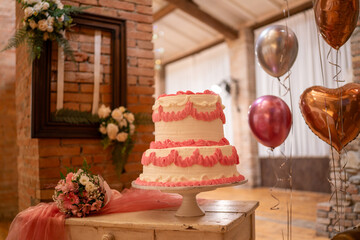 Elegant Wedding Cake Displayed With Pink Flowers And Heart Shaped Balloons Awaiting Celebration
