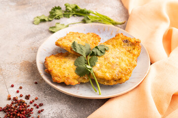 Fried crispy Chicken pancakes on brown concrete and orange textile. side view
