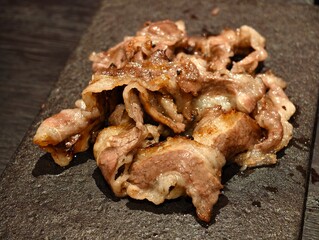 grilled sliced beef meat on stone slab