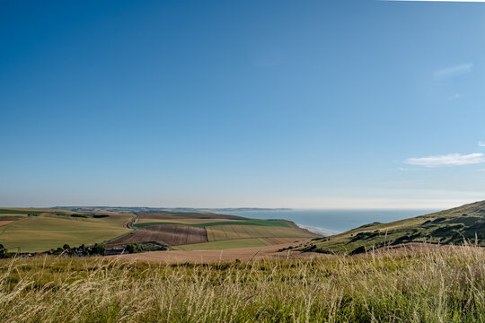 Cap Blanc-Nez, Escalles, Pas-de-Calais, Hauts-de-France, France, July 29th, 2025, A breathtaking and stunning view of rolling green fields colliding with the vast ocean under a clear blue sky