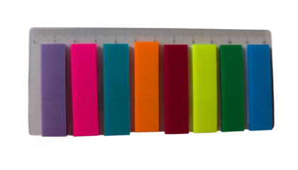 Set of colorful sticky bookmarks in rainbow shades placed next to a transparent ruler on a white background. Perfect for marking pages in books, notebooks, or planners.