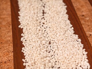 close up white dry glutinous rice grain on wooden board
