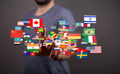A person interacting with a collection of world flags, illustrating international relations,...