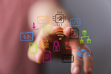 Close-up of a hand interacting with colorful digital icons representing data, network, and cloud technology.