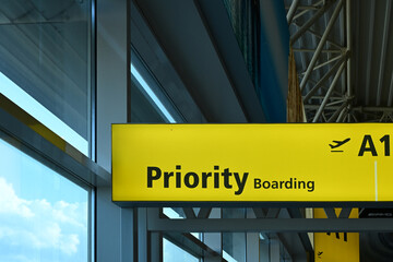 Airport sign indicating Priority Boarding for selected passengers, displayed in a terminal setting