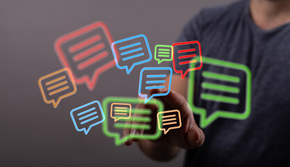 A hand touches digital chat bubbles, illustrating online communication, social media, and messaging in a modern, connected world.