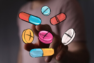 Close-up image of hand interacting with colorful pills and capsules. Healthcare, medicine, pharmacy concept.