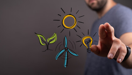 A man's hand interacts with digital symbols of renewable energy: sun, plant, wind turbine, light...