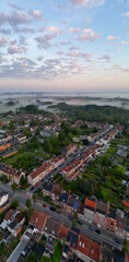 Fototapeta premium Bergensesteenweg, Sint-Pieters-Leeuw, Brussels, Belgium, 13th of May, 2025, A stunning aerial shot captures a peaceful neighborhood beautifully nestled in nature during a breathtaking sunrise