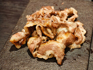 grilled sliced beef meat on stone slab
