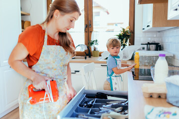 Mother and son in colorful clothes preparing breakfast together in kitchen