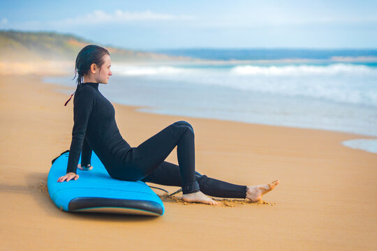 Surfer. Teenage girl resting with the surf board near the ocean. First surfing lesson. Amateur surfer. Surfing training. Photo for surfing school advertising on social media. - Powered by Adobe