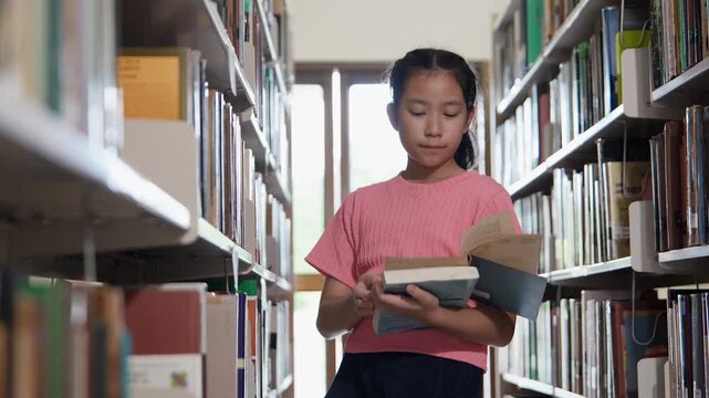 Young girl reading book in library filled with shelves, where education brings happiness and joy to every page.