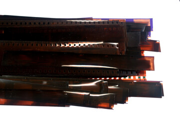 a stack of photographic film strips, typically 35mm film that was a common format for still photography, the small rectangular images on the film are the negatives of photographs, old vintage retro