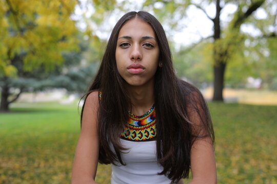 Serious young ethnic woman wearing beaded collar