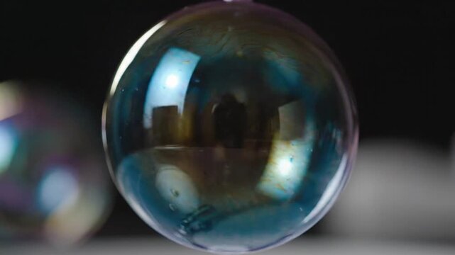 Close-up of a soap bubble with iridescent colors and reflections.