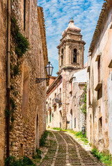old narrow italian street in traditional mediterranean style with yellow stone walls and beautiful windows. Amazing antuque buildings on a old inalian street.
