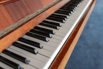 Close-up of a classic wooden piano keyboard. Musical instrument for lessons, concerts, and creating melody. Music education and art concept background.