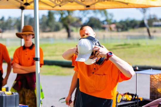 student trade apprentice putting on earmuffs PPE at training course