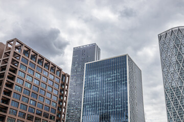 Modern glass skyscrapers and corporate towers under dramatic overcast sky
