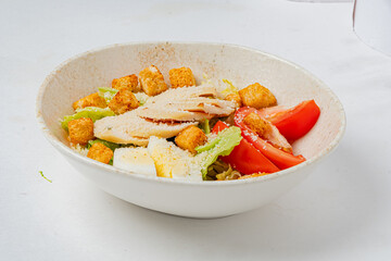 Colorful salad features grilled chicken, croutons, and fresh tomatoes, perfect for a healthy lunch