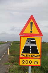icelandic road sign warning that the paved road will end and turn into a gravel road (malbik endar means end of paved road)