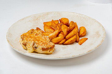A warm baked meal accompanied by golden potato wedges on a simple plate, perfect for a hearty lunch