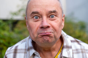 Astonished senior man, male face with silly expression and funny mimic, strong facial surprise and...