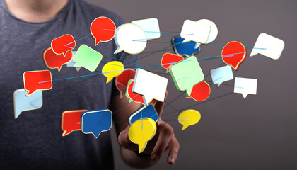 Conceptual image showing a hand interacting with floating speech bubbles representing digital communication social media connection and networki